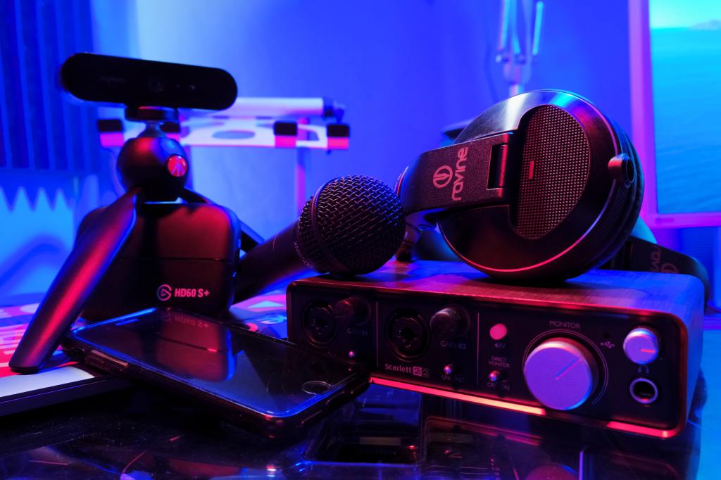 A microphone, pair of headphones, and camera on a table